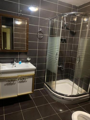 une salle de bain avec douche et lavabo dans l'établissement Blue Mercury Hotel, à Erbil