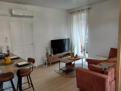 a living room with a couch and a tv at Le Temps des Cerises in La Cresse