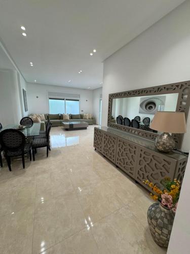 a living room with a large mirror and a table at Marina Puerto in Marina Smir