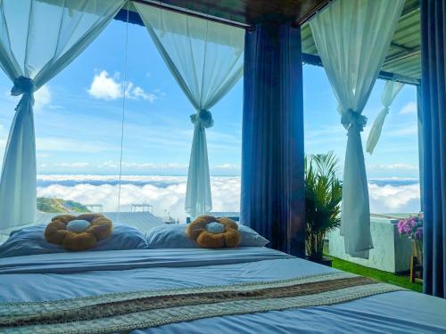 a bedroom with a bed with large windows at วันเดย์ภูทับเบิก in Ban Maeo Thap Boek