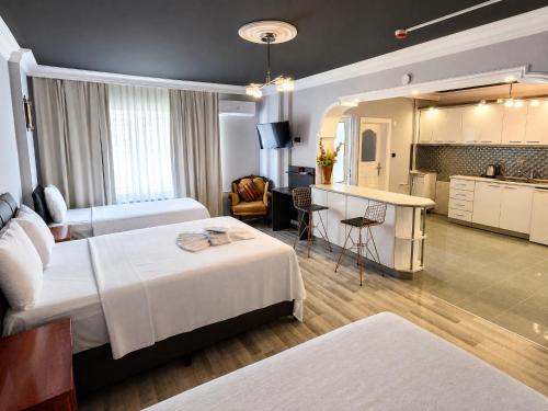 a hotel room with two beds and a kitchen at Corner Park Suites City Center Corlu in Çorlu