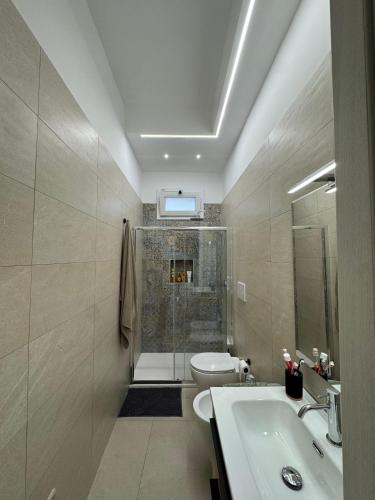 a bathroom with a shower and a toilet and a sink at Casa Vittoria - Moderno bilocale a pochi passi dal mare in Galatone