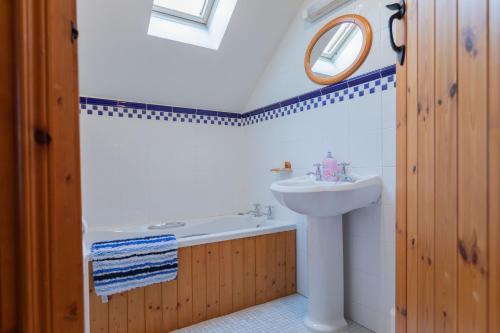 a bathroom with a sink and a bath tub and a mirror at The Barn at Bar Hall Bay in Portaferry