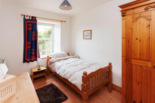 a bedroom with a bed and a window at The Barn at Bar Hall Bay in Portaferry