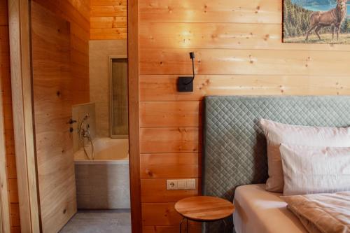 a bedroom with a bed and a bathroom with a tub at Schickster Sky Lodge und Chalet Rossi in Leutasch