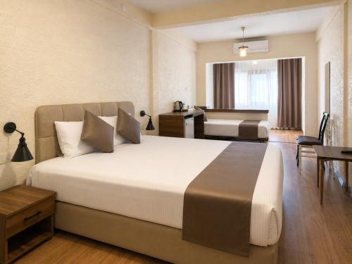 a hotel room with a large bed and a bathroom at La Pearl Konaklama in Istanbul