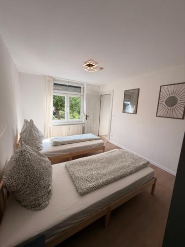 two beds in a room with a window at StadtQuartier Gardelegen in Gardelegen