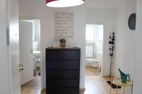 a bathroom with a black dresser and a toilet at Modern feel-good apartment in Bad Lippspringe