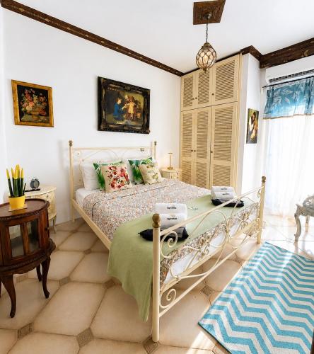 a bedroom with a bed and a table at Popis Maison in Rhodes Town