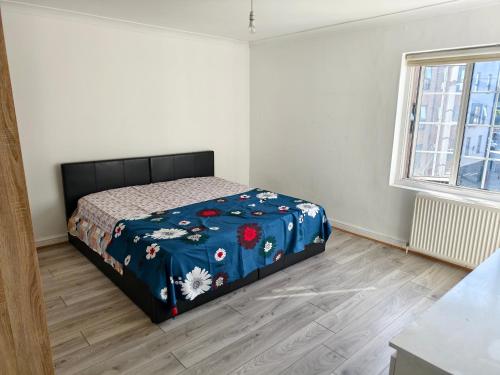 a bedroom with a bed with a blue blanket at Shriji Homes in Watford West Station