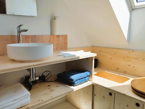 a bathroom with a sink on a wooden counter at Maison Ciaran in Trébeurden
