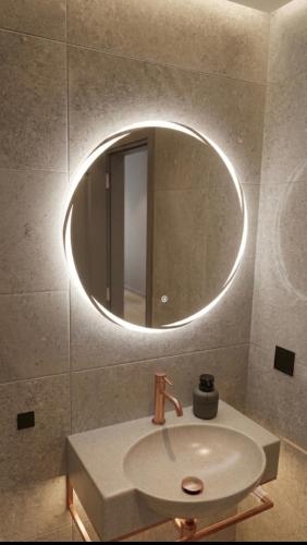 a bathroom with a sink and a round mirror at River Bridge in Žabljak