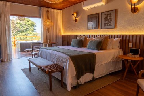 a hotel room with a bed and a balcony at Pousada K in Pirenópolis