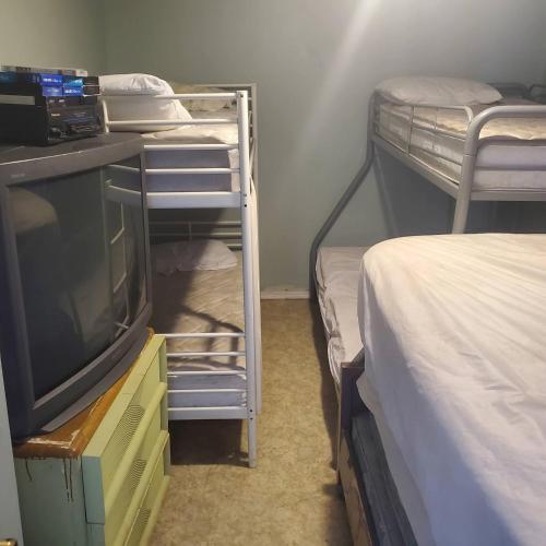a room with two bunk beds and a television at ARMANI MANOR Rustic UNIT 2 in Wildwood