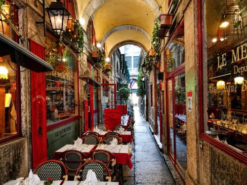 an alley way with tables and chairs in a building at Gîte du Vieux Lyon in Lyon