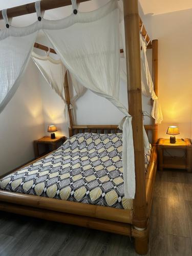a bedroom with a canopy bed with two night stands at Entre Lac et Océan in Hourtin