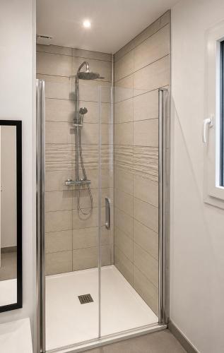a shower with a glass door in a bathroom at Entre Lac et Océan in Hourtin