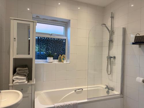 a white bathroom with a tub and a sink at The Hideaway - Secluded Studio Annexe in Cambourne