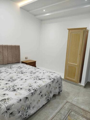 a bedroom with a bed and a wooden door at Maison lemjid in Kelibia
