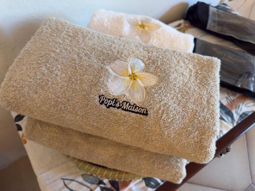 a towel with a flower on it on a rack at Popis Maison in Rhodes Town