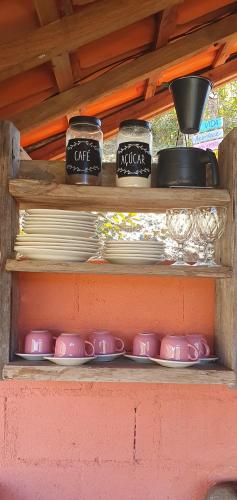 a shelf with plates and bowls and dishes on them at Chalé Estalagem Vô Jasôn in Itamonte