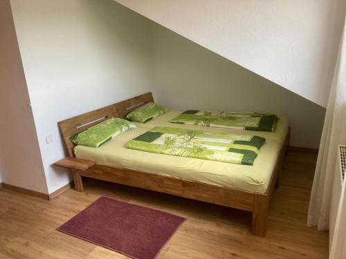 ein Schlafzimmer mit einem Bett mit grünen Laken und Kissen in der Unterkunft Alb-Blick in Göppingen