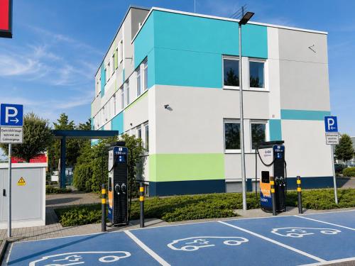 a parking lot in front of a building with parking meters at looks-inn in Viernheim