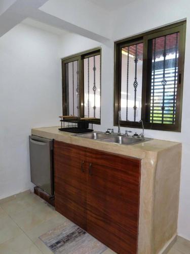 ein Badezimmer mit Waschbecken und zwei Fenstern in der Unterkunft Casa Las Brisas in Progreso
