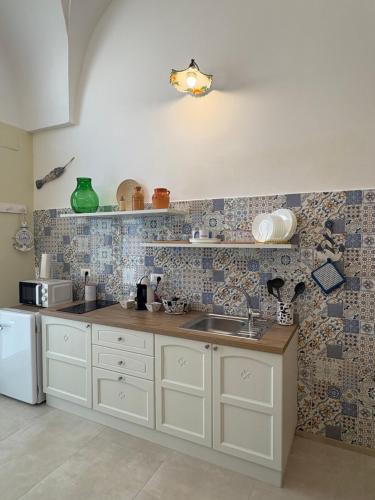 a kitchen with a sink and a counter top at A casa di Marina Mare Centro posto auto in zona in Porto Cesareo