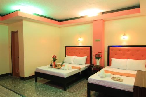 a hotel room with two beds and two tables at RSG Microhotel in General Santos