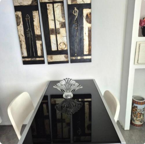 a dining room table with two chairs and a painting at T1 Amadora in Amadora