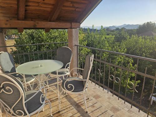 a patio with a table and chairs on a balcony at MontSky Apartment - Podgorica Airport in Mitrovići