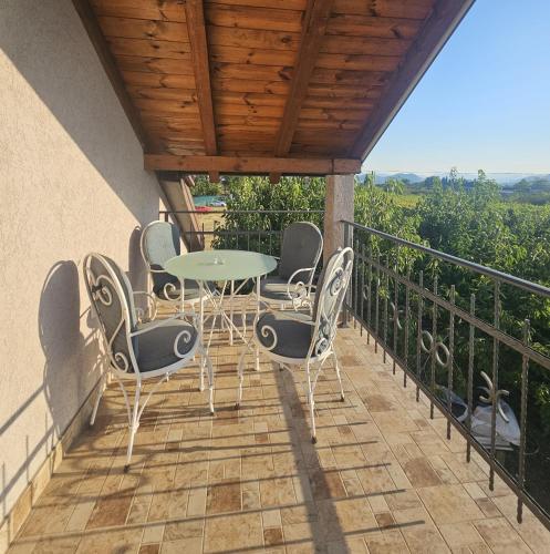 a patio with a table and chairs on a balcony at MontSky Apartment - Podgorica Airport in Mitrovići