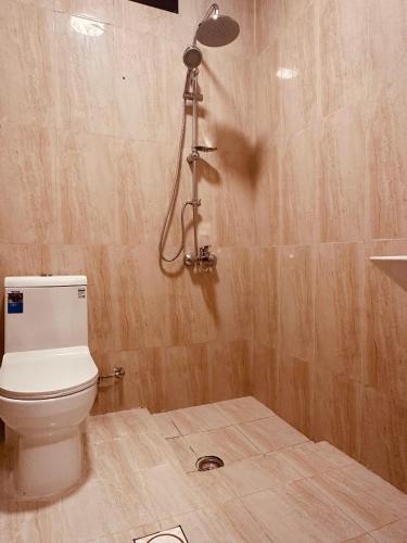 a bathroom with a toilet and a shower at Britstar Suites Salalah in Salalah