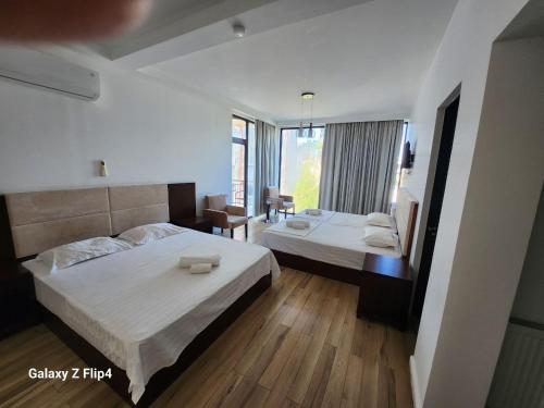 a bedroom with two beds and a large window at Belgrad Rustaveli Kobuleti in Kobuleti