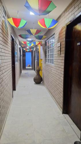 a hallway with colorful umbrellas hanging from a ceiling at Kitnet Tijolo Ecológico 02 in Tamandaré