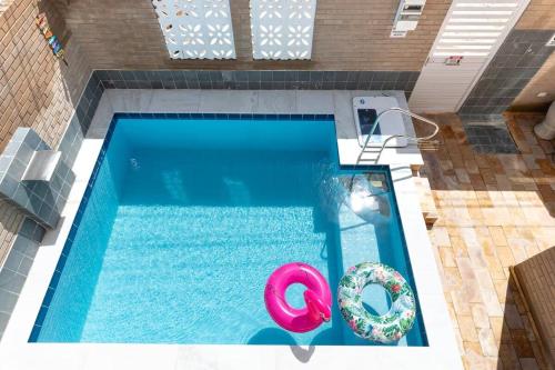 an overhead view of a swimming pool with a float at Kitnet Tijolo Ecológico 02 in Tamandaré