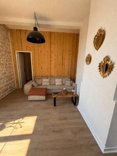 a living room with a couch and a table at L'Écrin de Pierre - Gare & Centre à pied - Charme & Calme in Mâcon