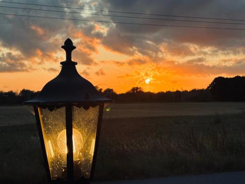 Eine Straßenlaterne vor dem Hintergrund des Sonnenuntergangs in der Unterkunft Penberthy Cabin in Offord Cluny