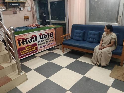 a woman sitting on a couch in a waiting room at Shiddi pelesh yatri niwas in Maihar