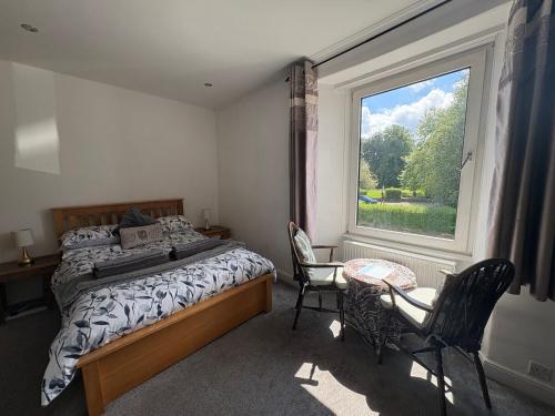 a bedroom with a bed and a large window at Birch Tree House in Windermere