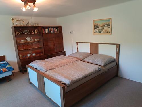 a bedroom with a bed and a dresser in it at Vidiecky dom in Veľký Krtíš