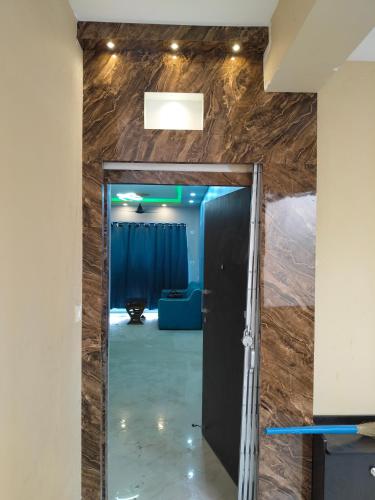 a hallway with a door into a room with a couch at North Grande in kolkata