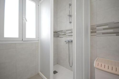 a white bathroom with a shower and a window at Alba Solis in Vejer de la Frontera