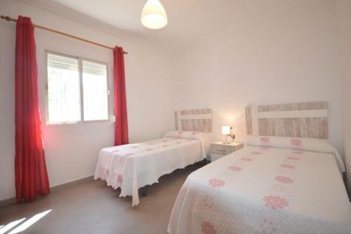 a bedroom with two beds and a window at Alba Solis in Vejer de la Frontera