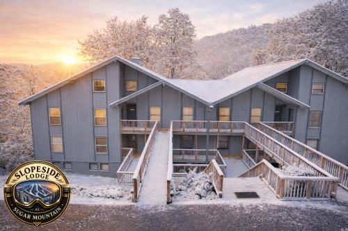 a large building with snow in front of it at Slopeside Lodge at Sugar Mountain in Sugar Mountain