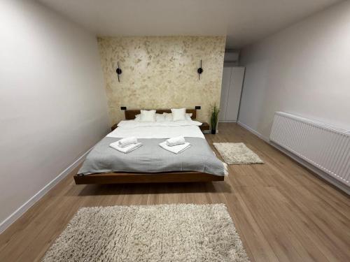 a bedroom with a large bed and two rugs at Cabanutele "La Garaj" in Ocna-Mureşului