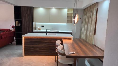 a kitchen with a sink and a counter with chairs at Villa Hill in Tríkala