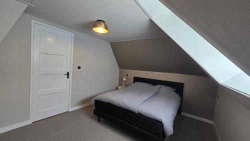 a small bedroom with a bed and a window at Vakantiewoning In de boerderij in Arum