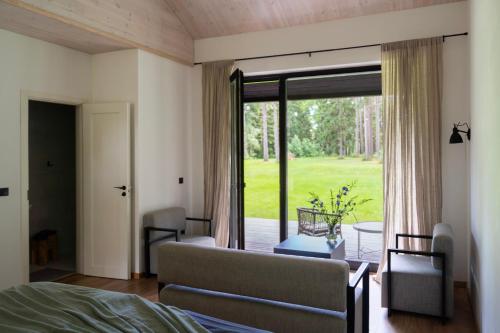 a bedroom with a bed and a sliding glass door at Hõbekala Guesthouse in Kalana